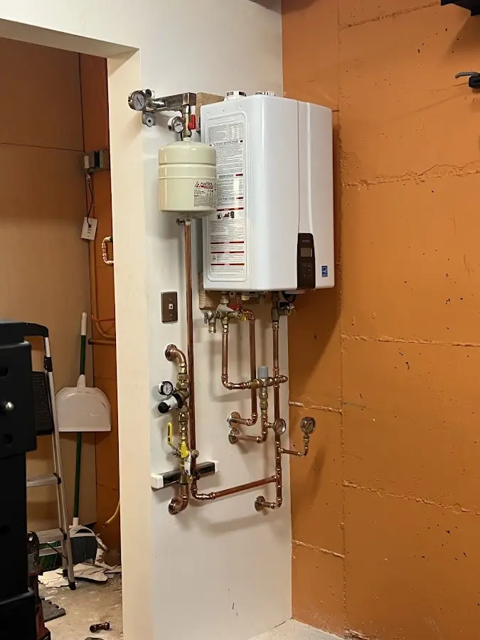 Plumbing technician inspecting water heater connections in Langley Park